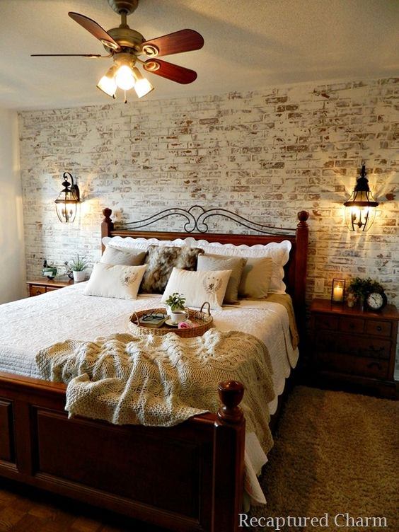 اتاق خواب دو نفره با تخت و فرش قهوه ای که دیوار پشت تخت آن به طرح آجرهای قهوه ای و کرم است